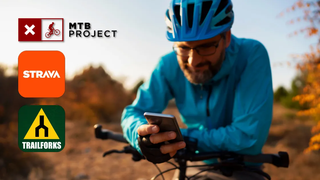 Strava vs Trailforks vs MTB Project: Ride Legally (2026) 2 Rider checking trail access on a phone before entering a posted trailhead